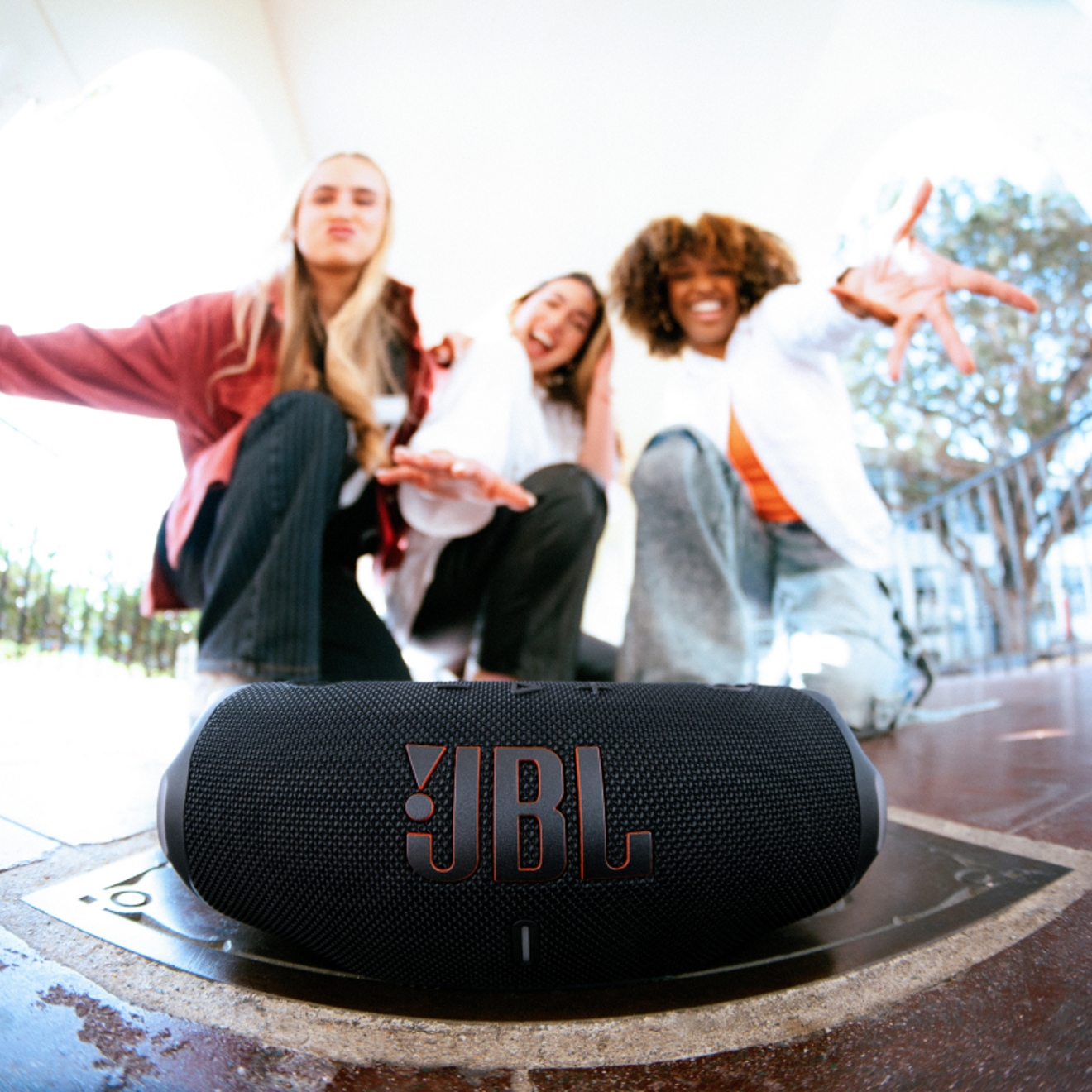 Friends dancing to a JBL Charge device