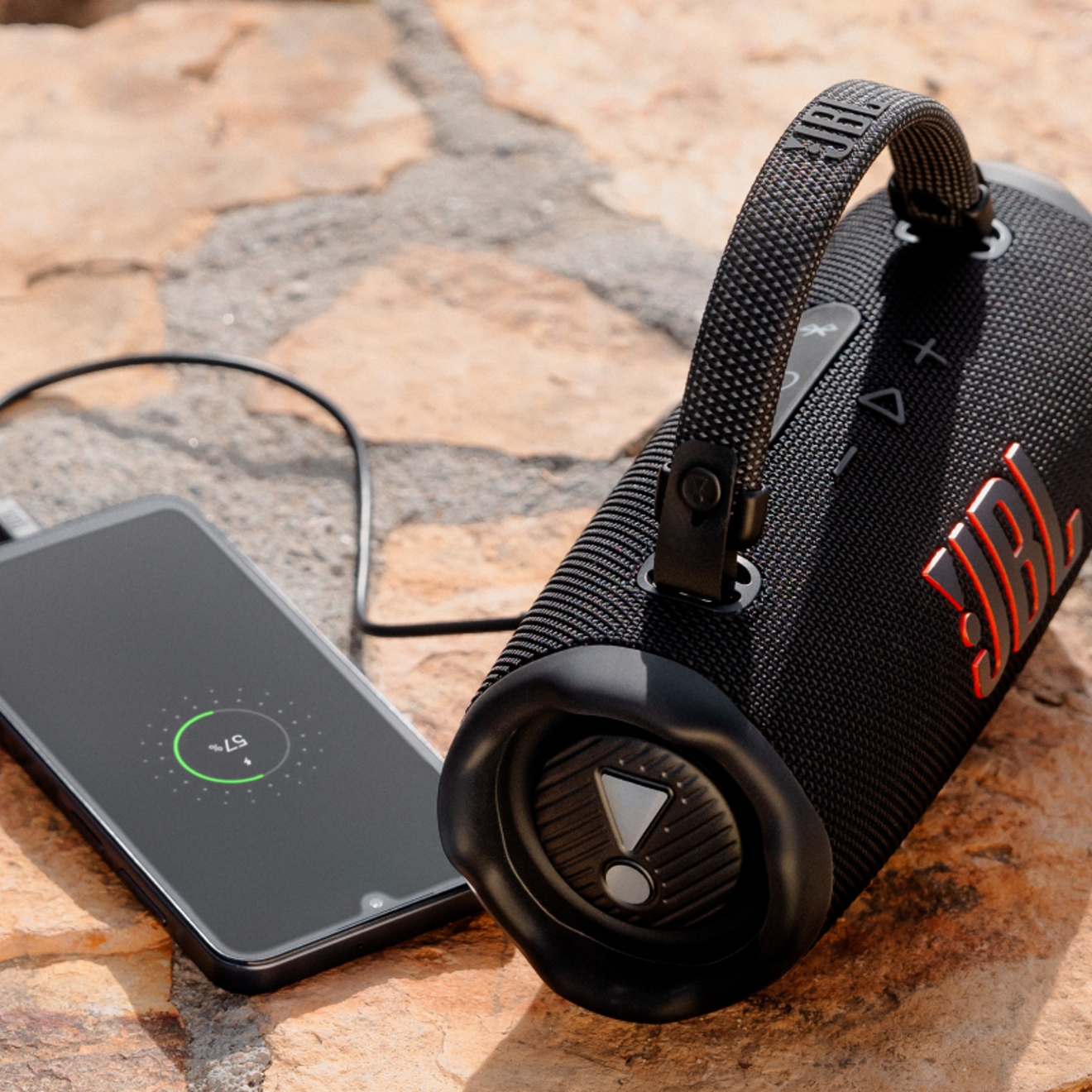 A JBL Charge is plugged into a smart phone device