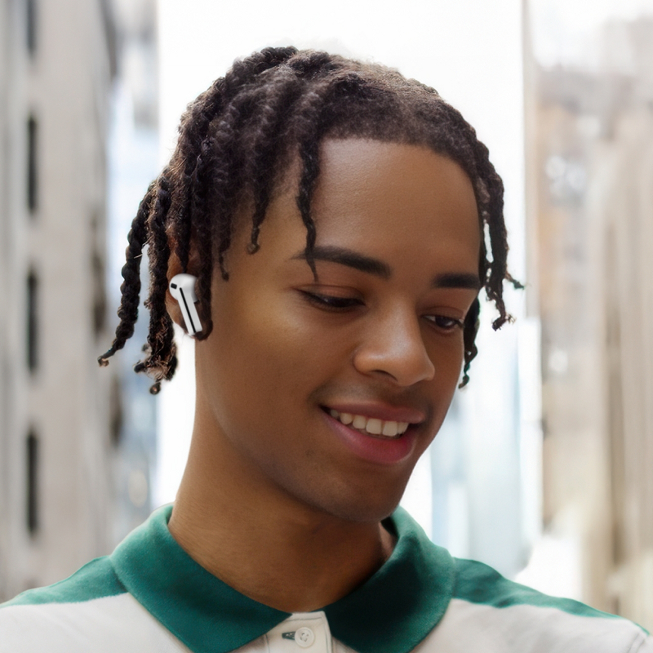 Person wearing Galaxy Buds3 FE outside in a large city.