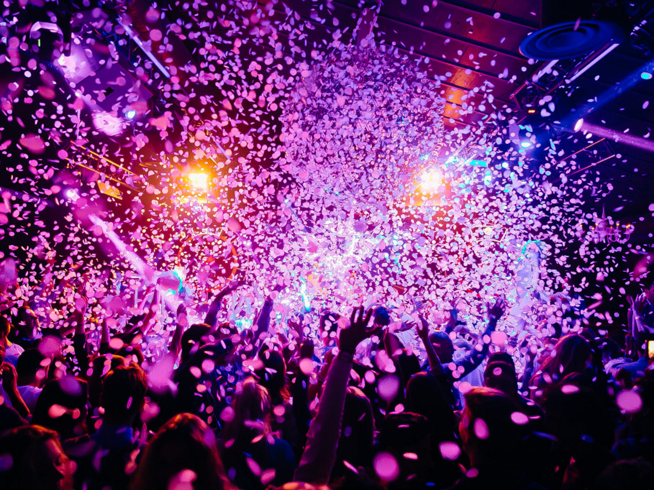 Group of people celebrating with confetti falling from above.