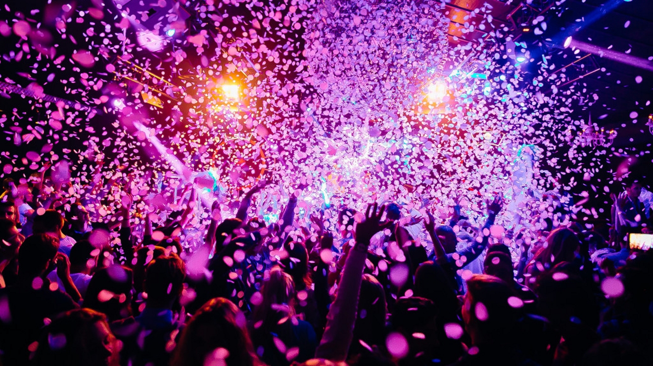Group of people celebrating with confetti falling from above.