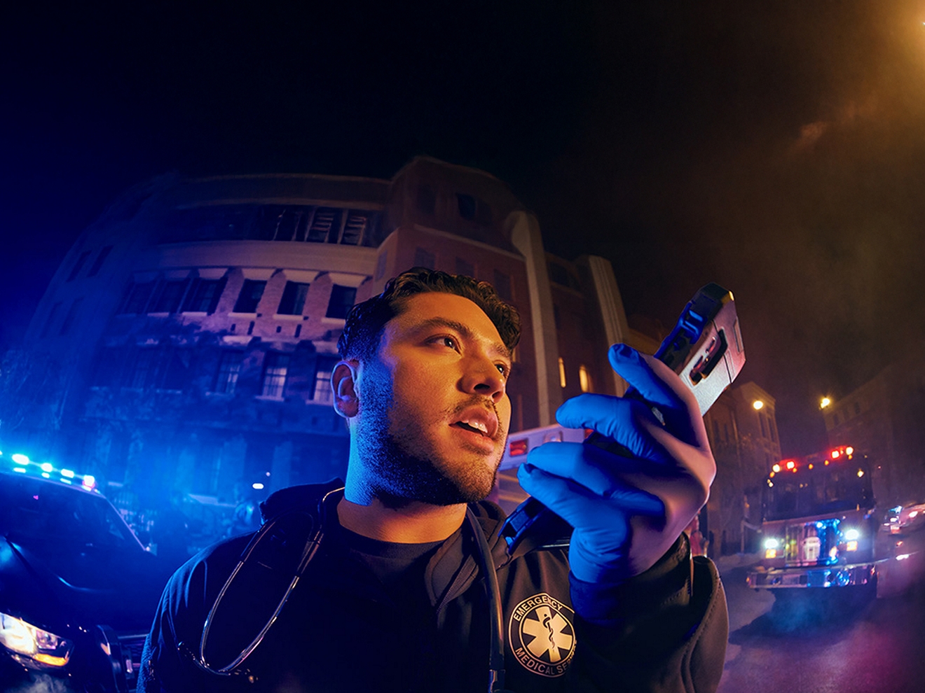 An EMT at the site of an emergency communicates via their 5G-connected smartphone.