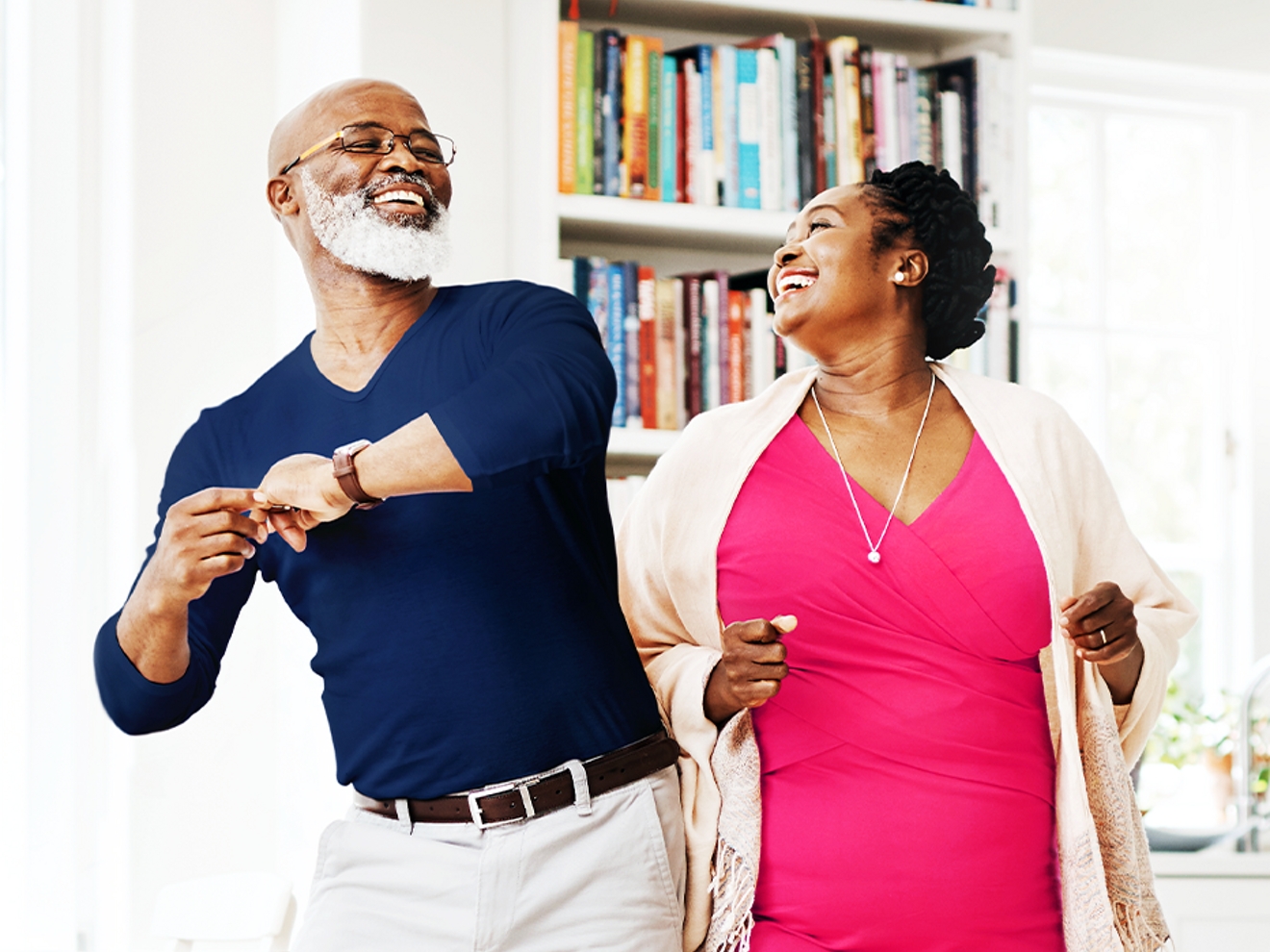 Older couple dancing side by side in a home kitchen.