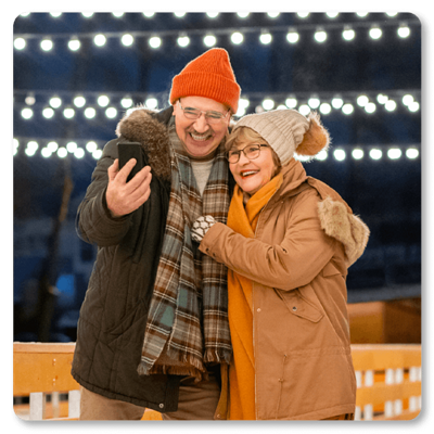 2 smiling people holding a phone
