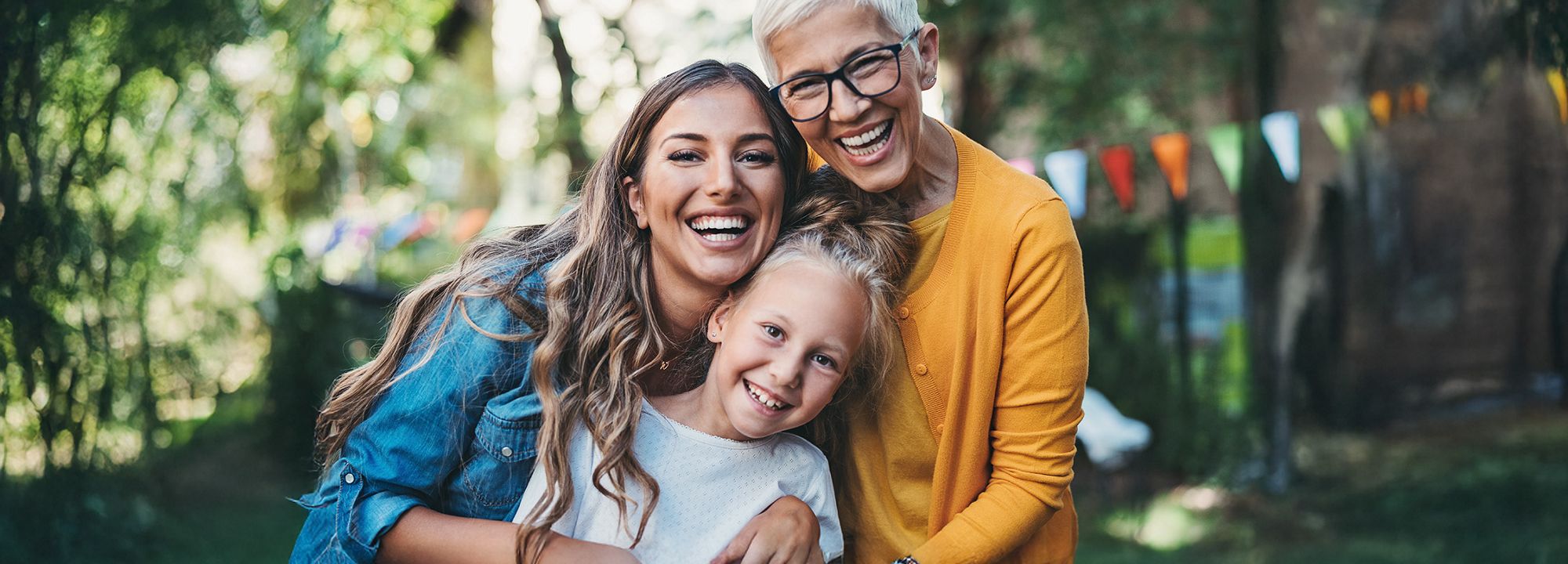 Grandmother, mother, and daughter all smiling