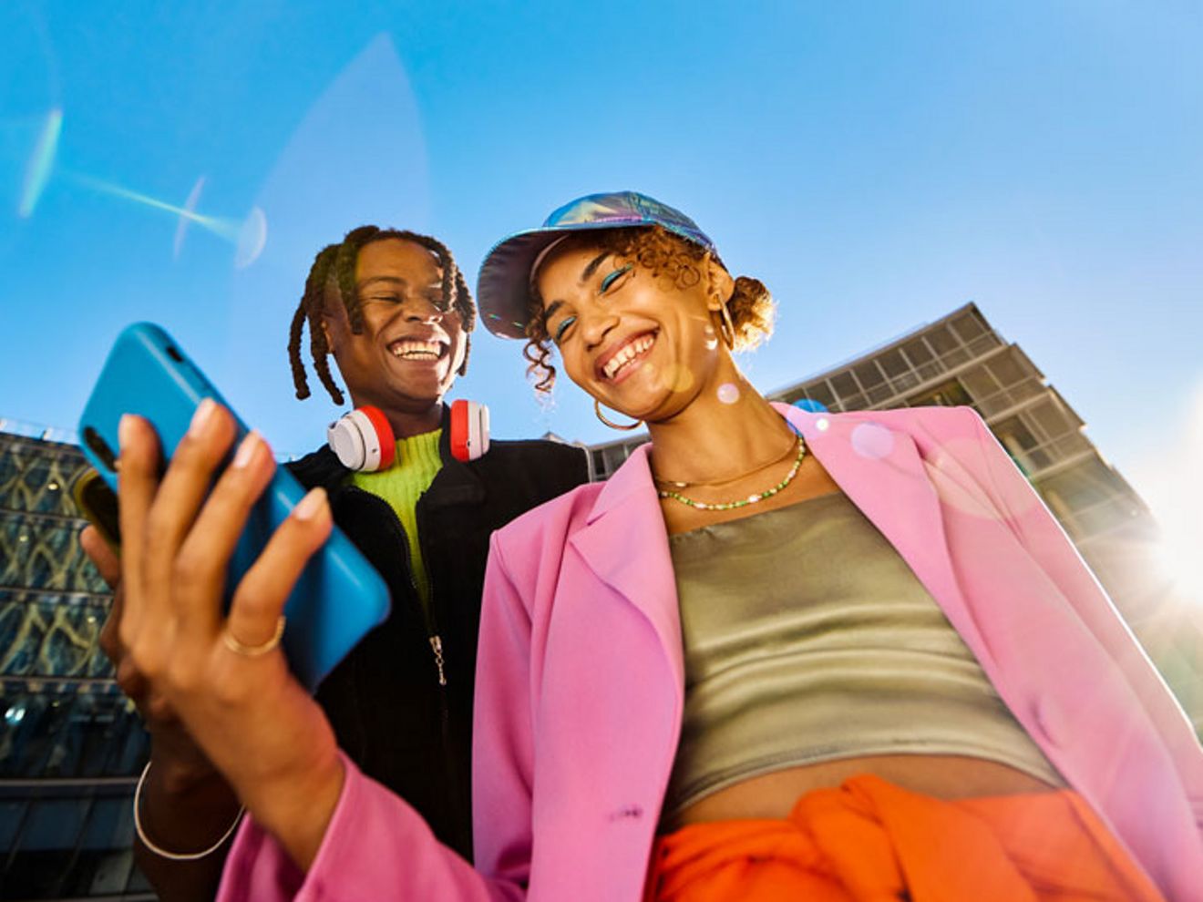 Two people smiling, one looking at a phone.