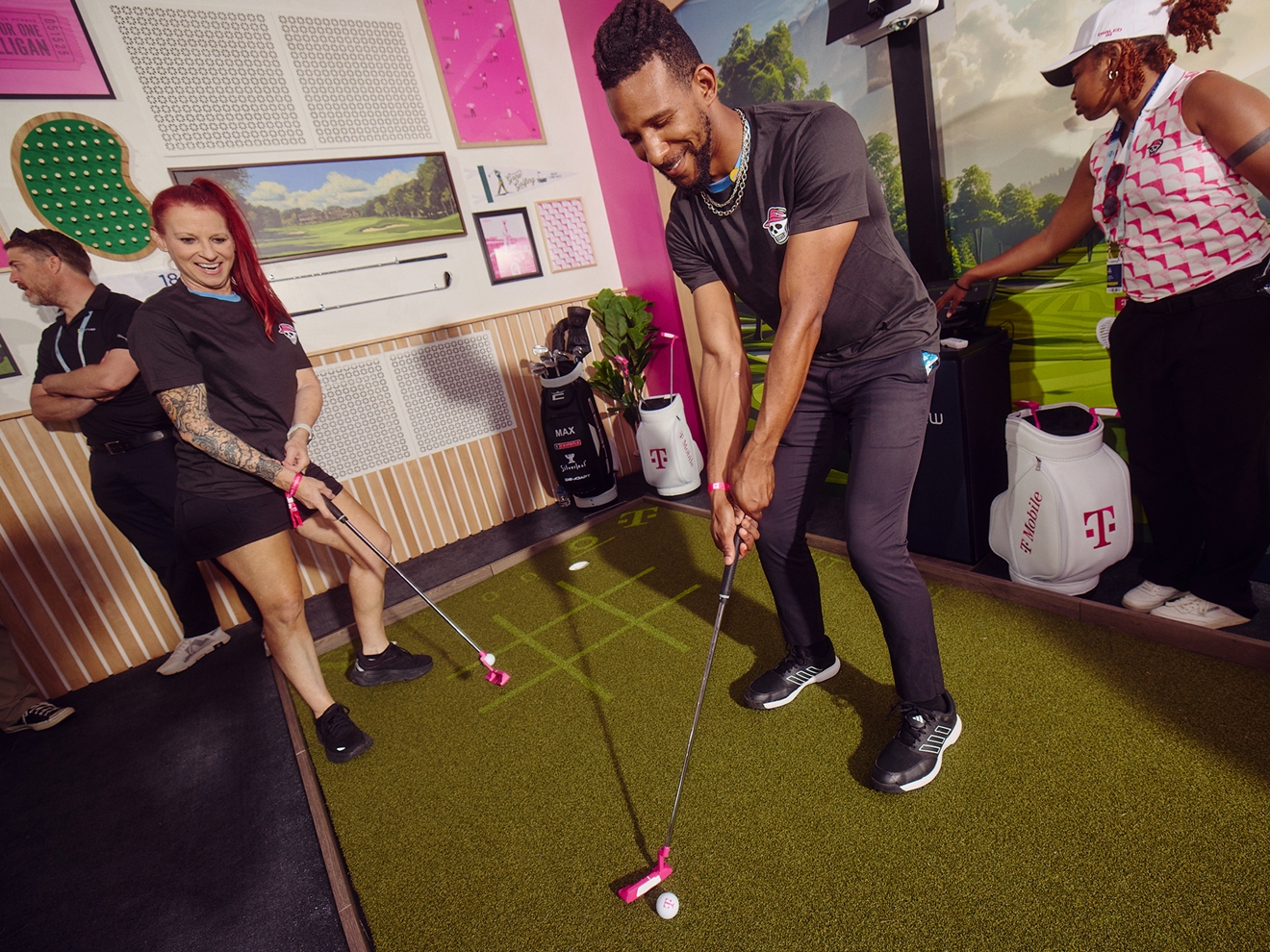 Two people enthusiastically playing PuttView inside Club Magenta. 