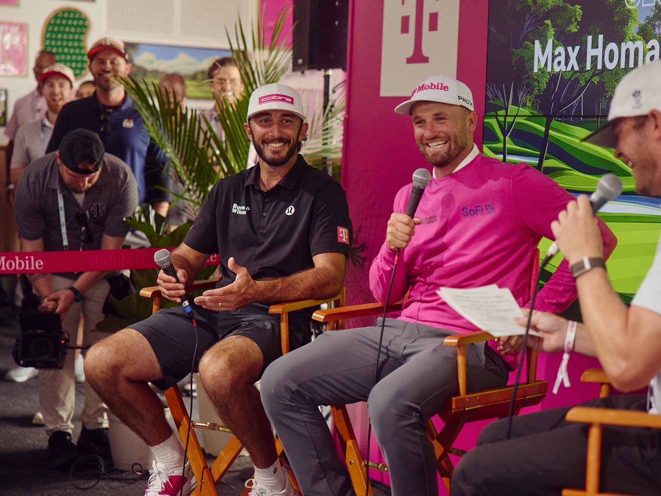 Max Homa and Wyndham Clark being interviewed in front of an audience inside Club Magenta. 