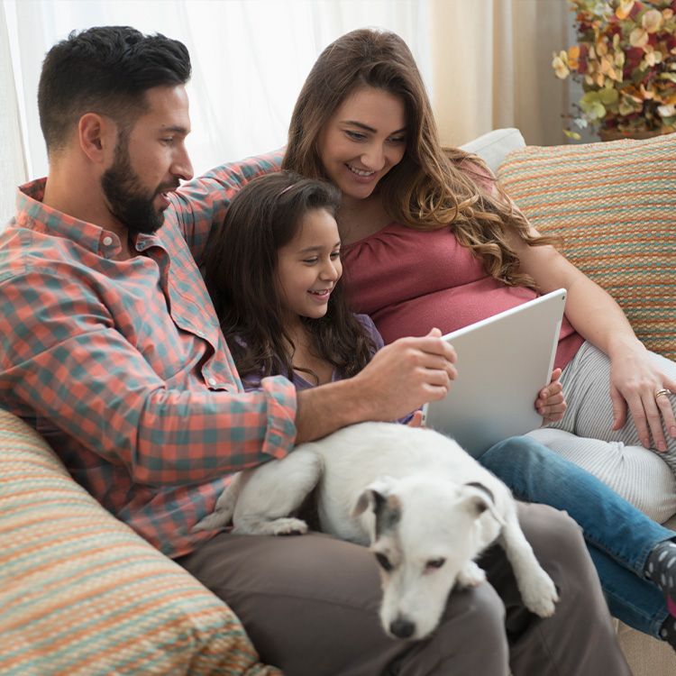 A family of three looking at a tablet 