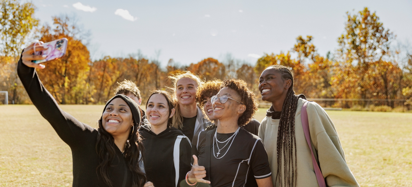 Group of friends in a field taking a selfie. 
