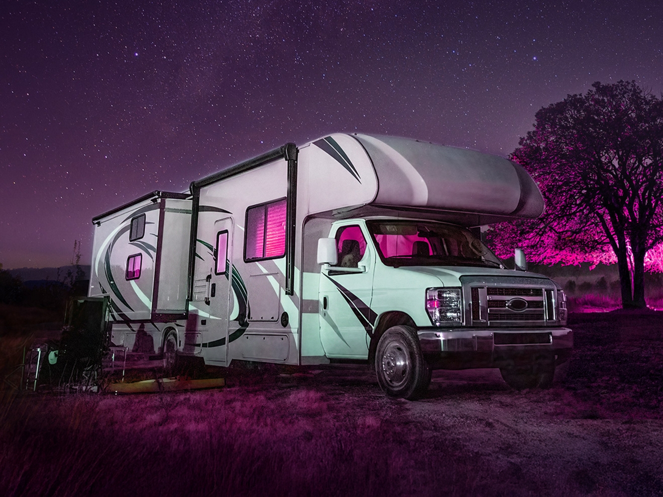 RV parked at a campsite on a starry night. 
