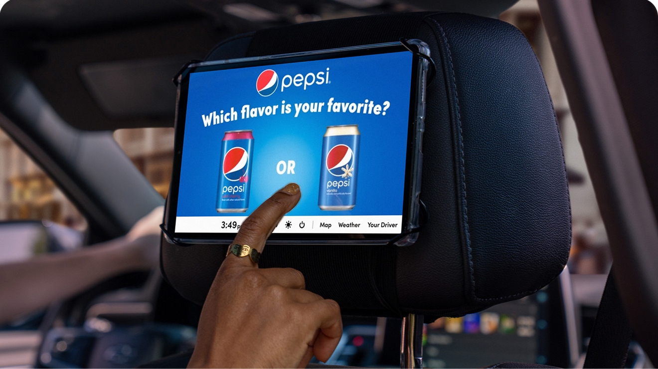 Backseat tablet with Pepsi ad on screen being tapped by finger