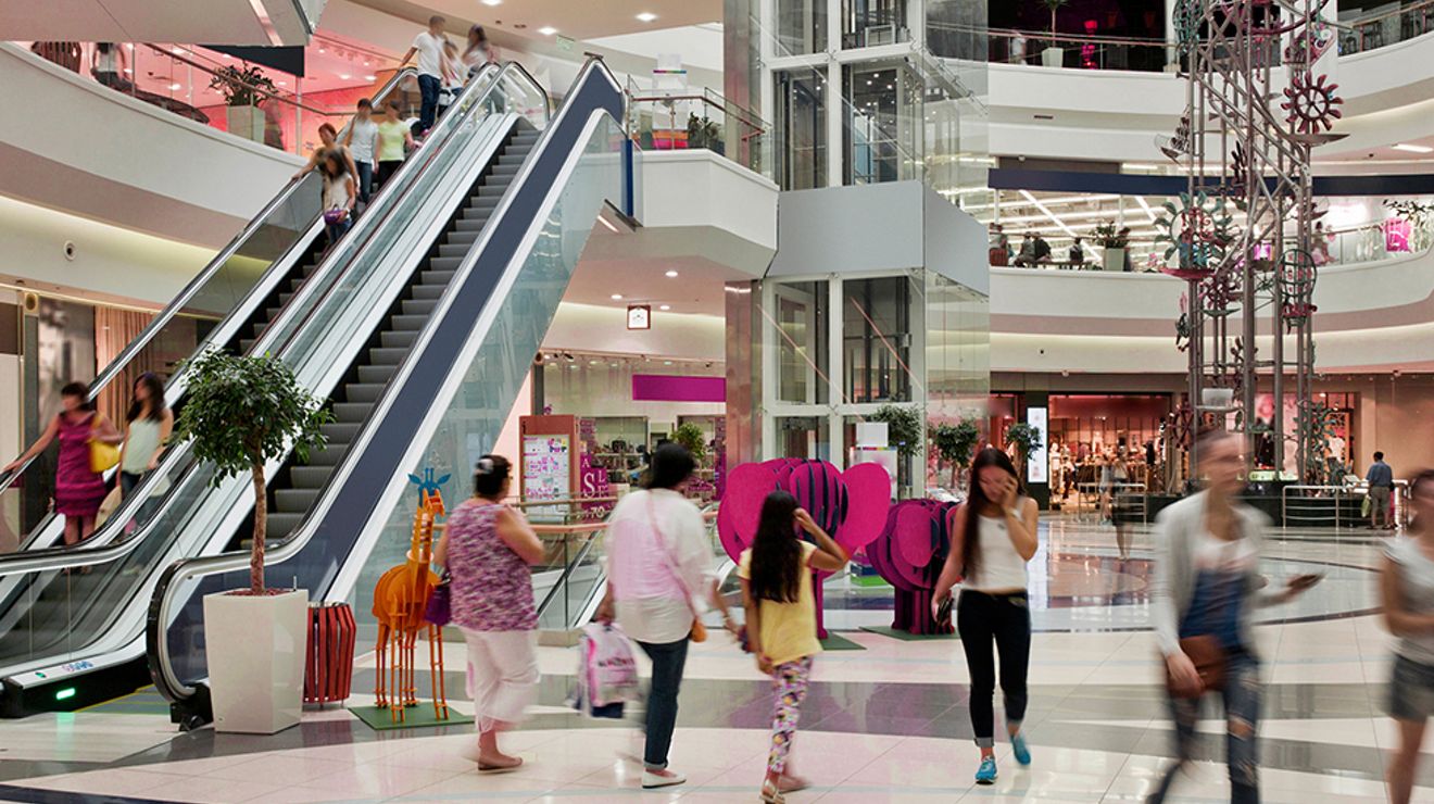 Multi-level shopping center filled with busy customers.