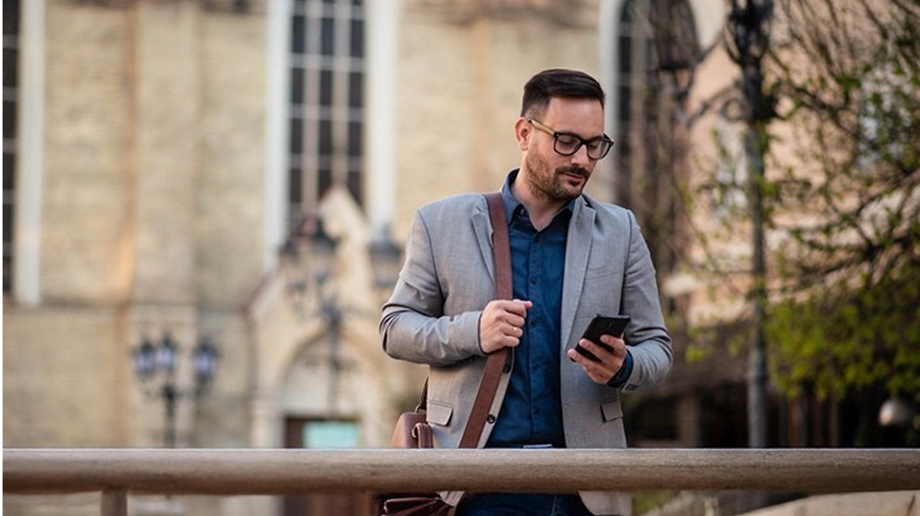 A businessperson sends a message through T-Mobile for Microsoft Teams as they walk outside.
