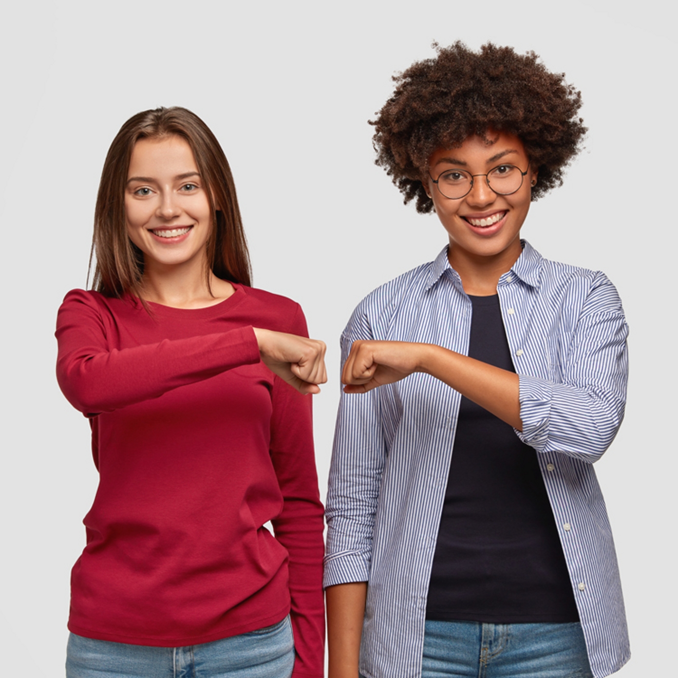 Two co-workers giving each other a friendly fist bump.