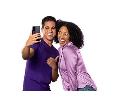 Hombre joven con camisa púrpura y pulgares hacia arriba posando con mujer joven con camisa púrpura más claro mientras se toman una selfie.