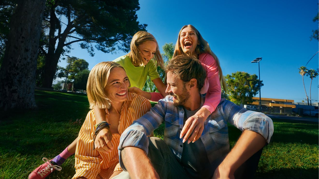 A group of friends are at a park, laughing.