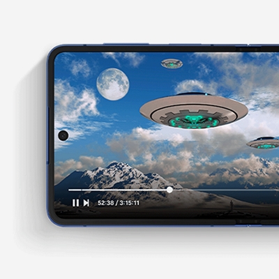 A photorealistic image of flying saucers hovering over a mountain range against a blue sky with the moon rising.
