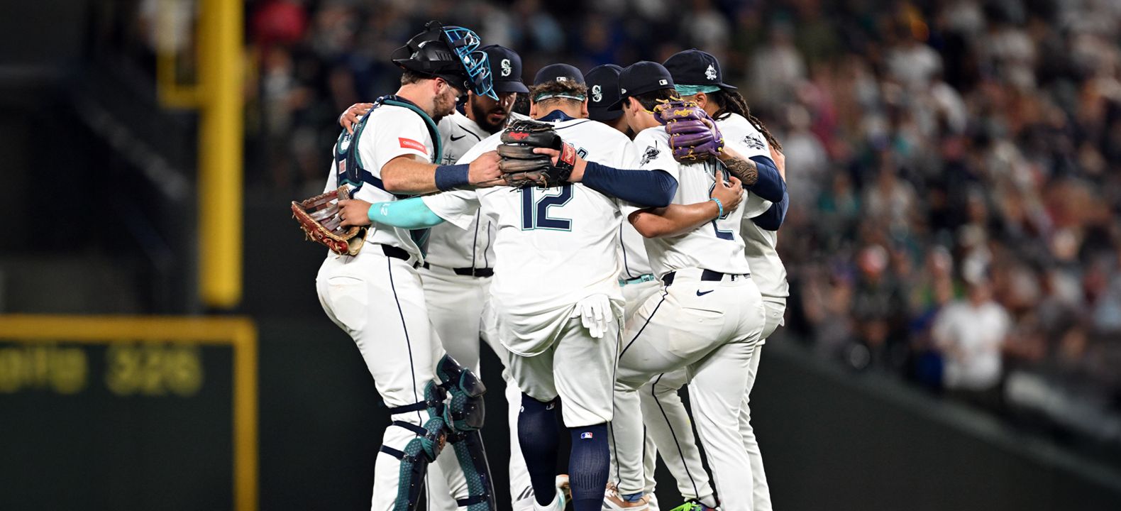 Baseball players huddling during a game. 