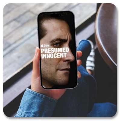 A phone screen shows an Apple TV+ promotion for Presumed Innocent.