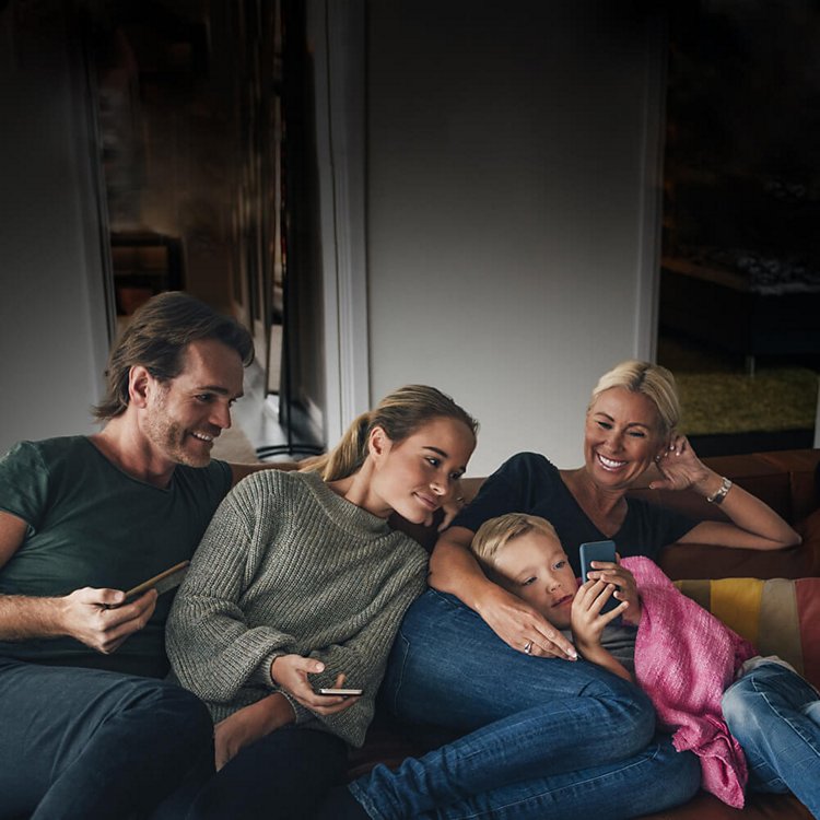Family on couch looking at mobile devices
