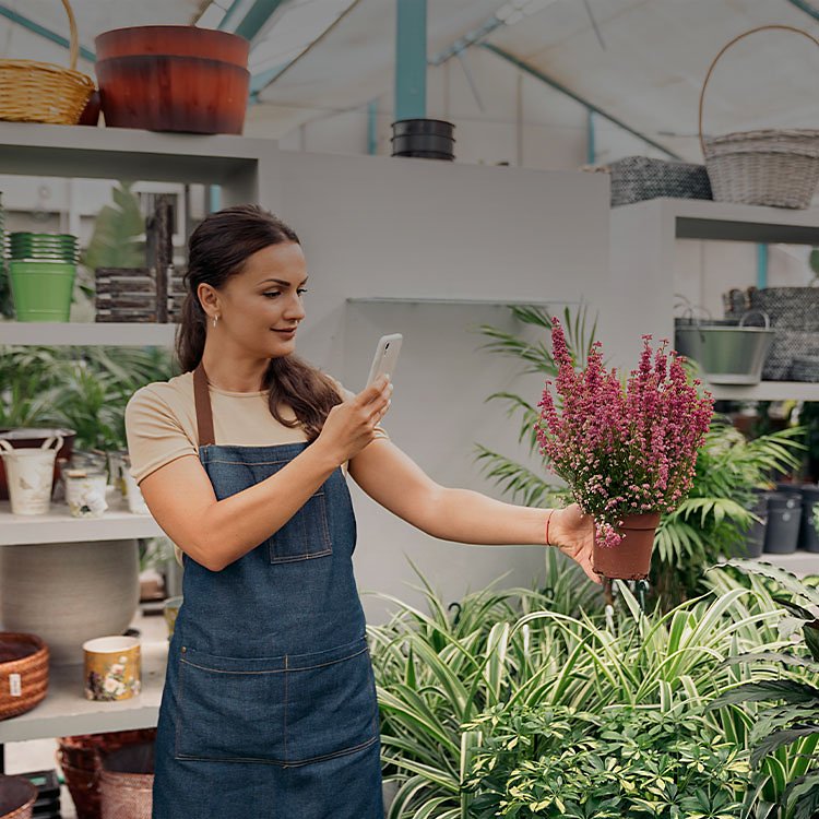 Woman taking a picture of a plant with a mobile phone
