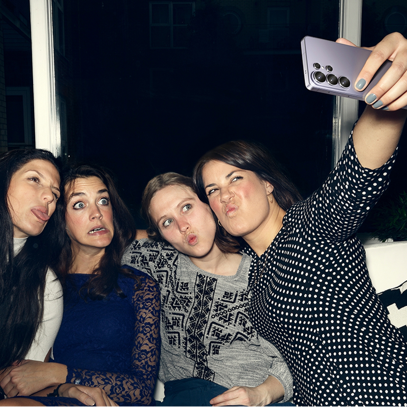 A group of women gathered taking a selfie making silly faces