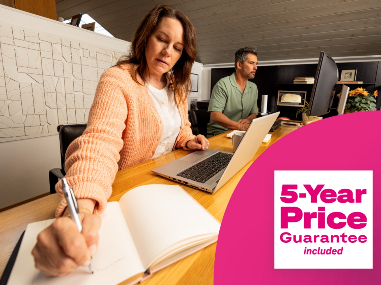 Woman at desk writing in notebook