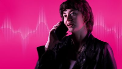 With energetic magenta waves behind her, a woman talks on a phone. 