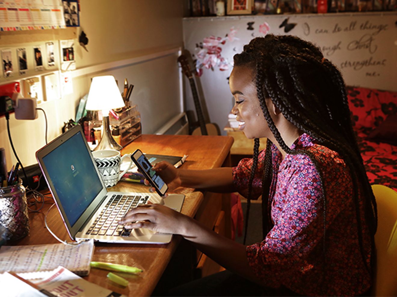 A woman working on her laptop in a college room.