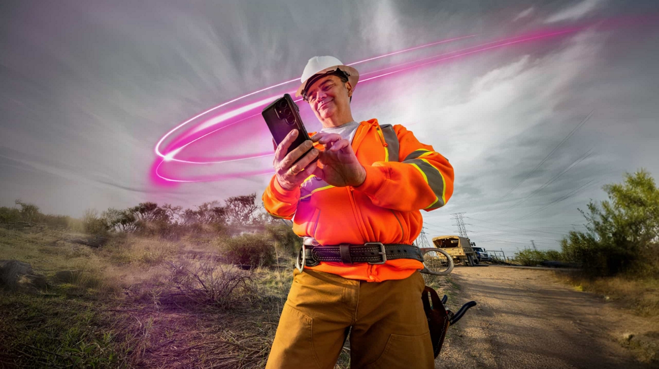 A utility specialist at work in the field uses T-Satellite with Starlink to check cell phone messages.