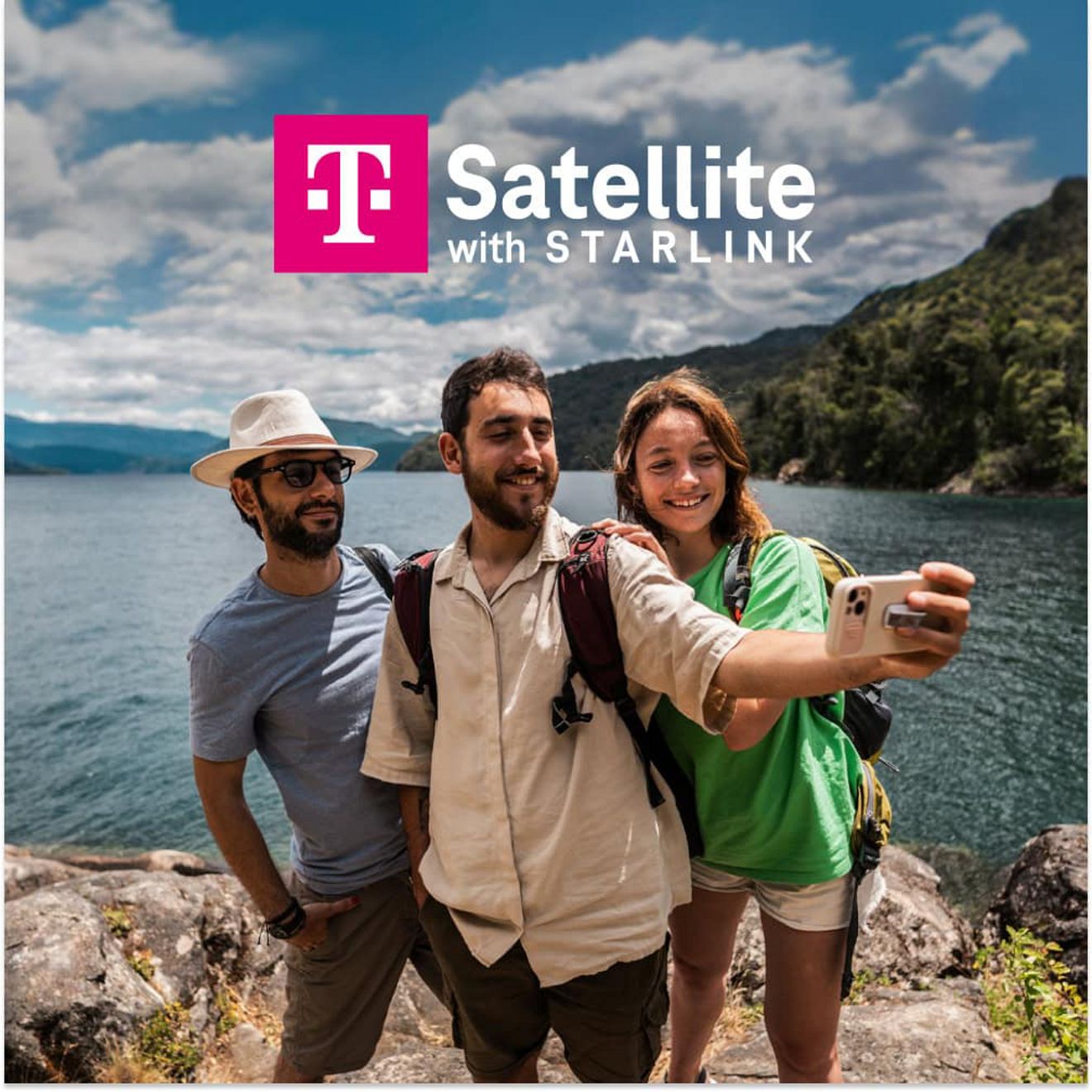 Group of friends taking a selfie on a rocky lakeshore with mountains in the background and “T Satellite with Starlink” text.