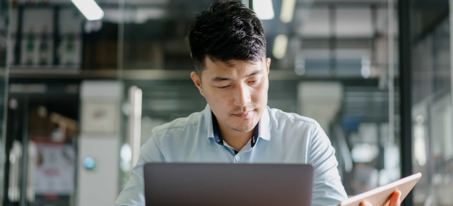 A business professional confidently works on their secure tablet and laptop.