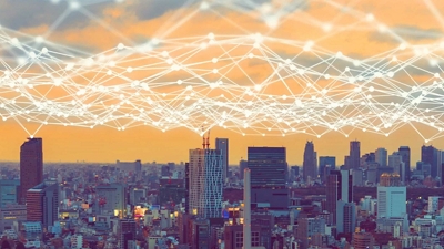 A connected grid of light represents a network hovering above a city skyline.