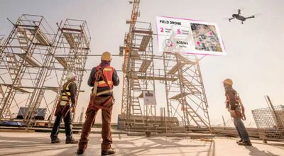 Three workers fly a drone to inspect a construction site.