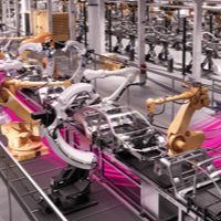 Robotic arms working on cars in a factory