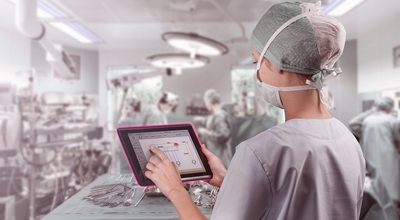 A surgeon using a tablet in an operating room