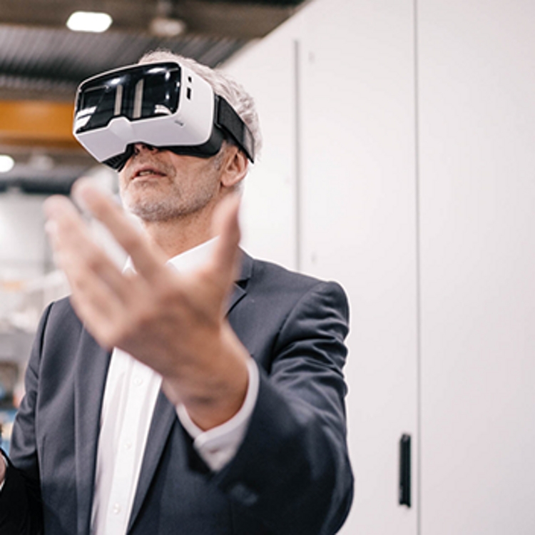 A man and a woman using VR goggles and wearing black suit jackets.