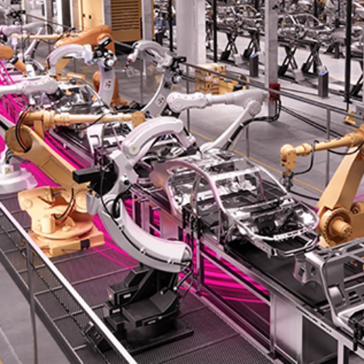 Robotic arms working on cars in a factory