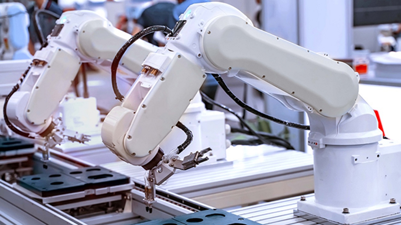 White robot arms on assembly line.