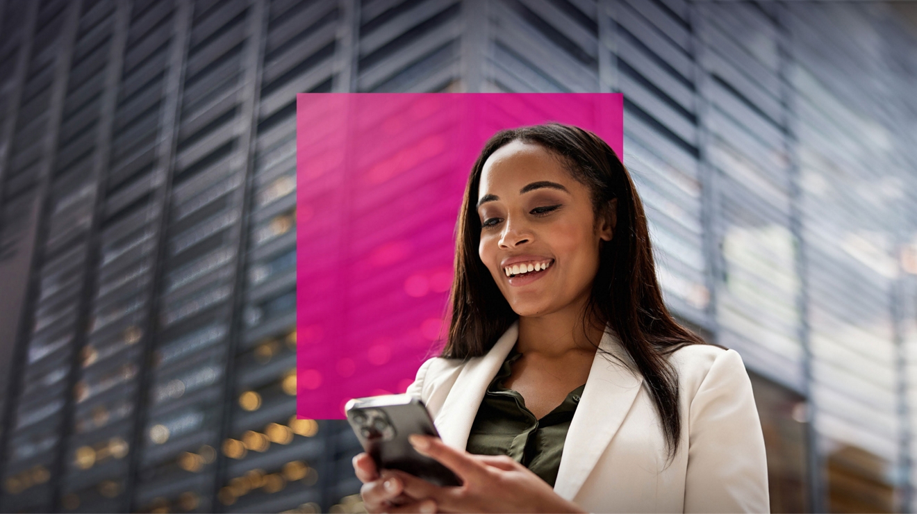 A happy government worker stands outside and uses the T-Mobile dedicated call and messaging app.