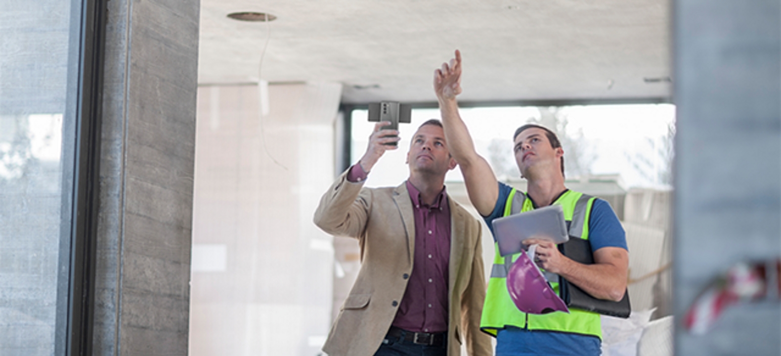 Smiling woman in white takes a piece of paper from a man in a blue shirt.