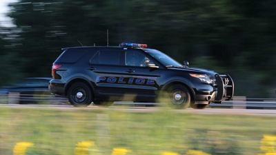 A police vehicle travels quickly along a road.