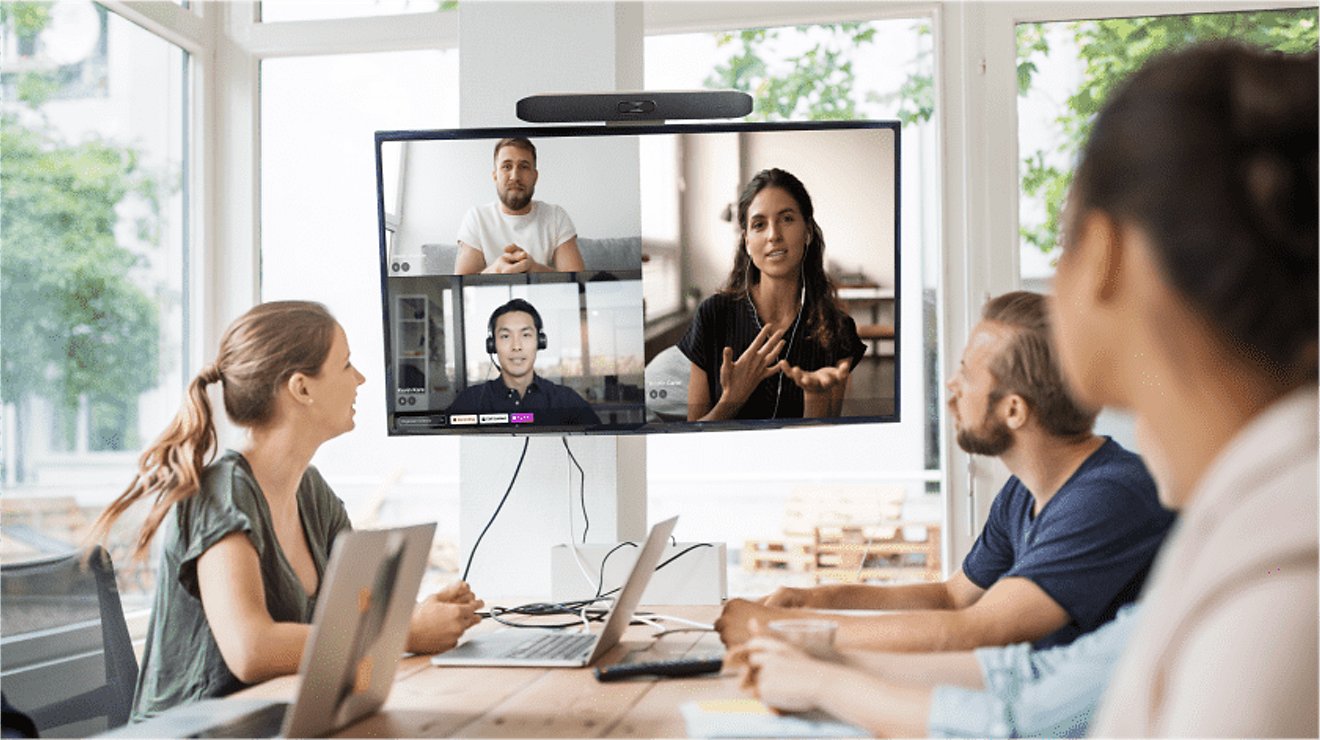 A team meets with their work-from-home colleagues using video conferencing software.