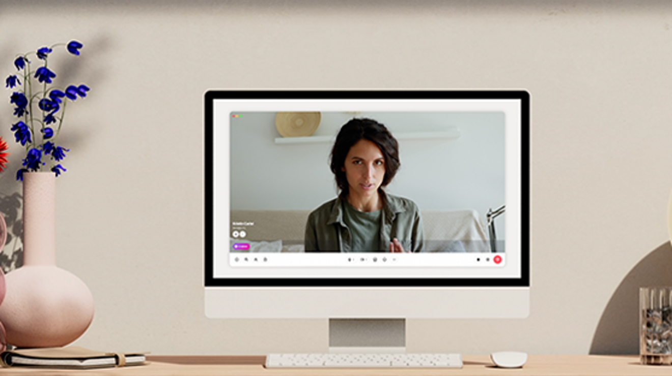 Desktop computer with woman in a Dialpad Ai Meeting onscreen.