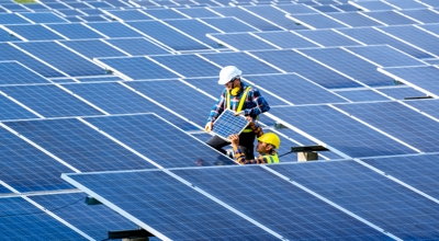 Two solar technicians install solar panels.