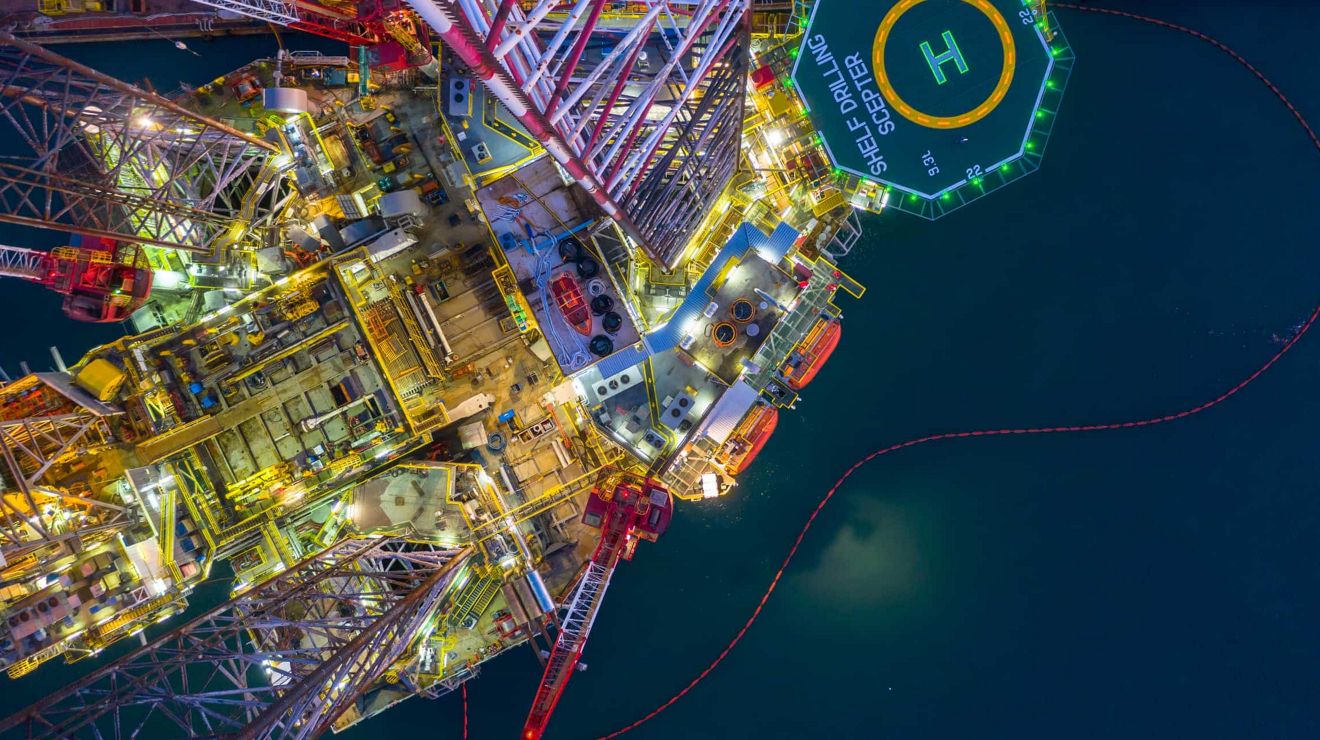 An aerial view of an offshore oil rig at night.