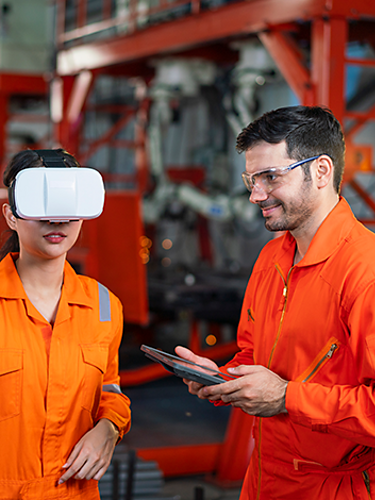 Worker wears a VR headset to complete a workplace safety training. Her instructor controls the experience with a tablet.