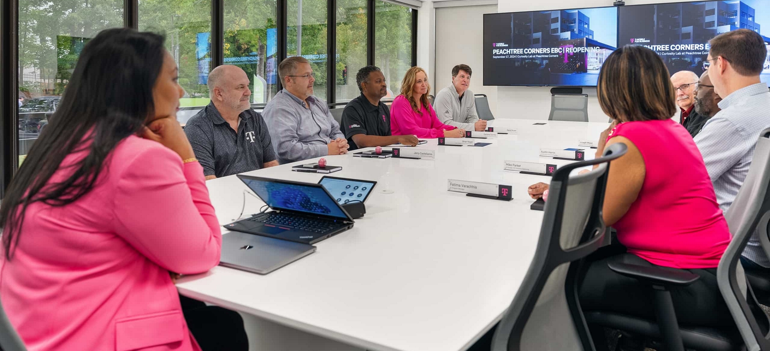 Business leaders and T-Mobile experts in a strategy meeting at an Executive Briefing Center.