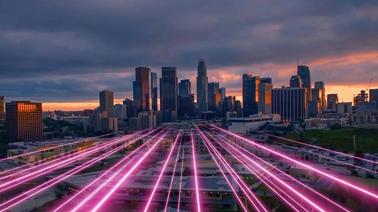 Magenta beams lead into a large city.